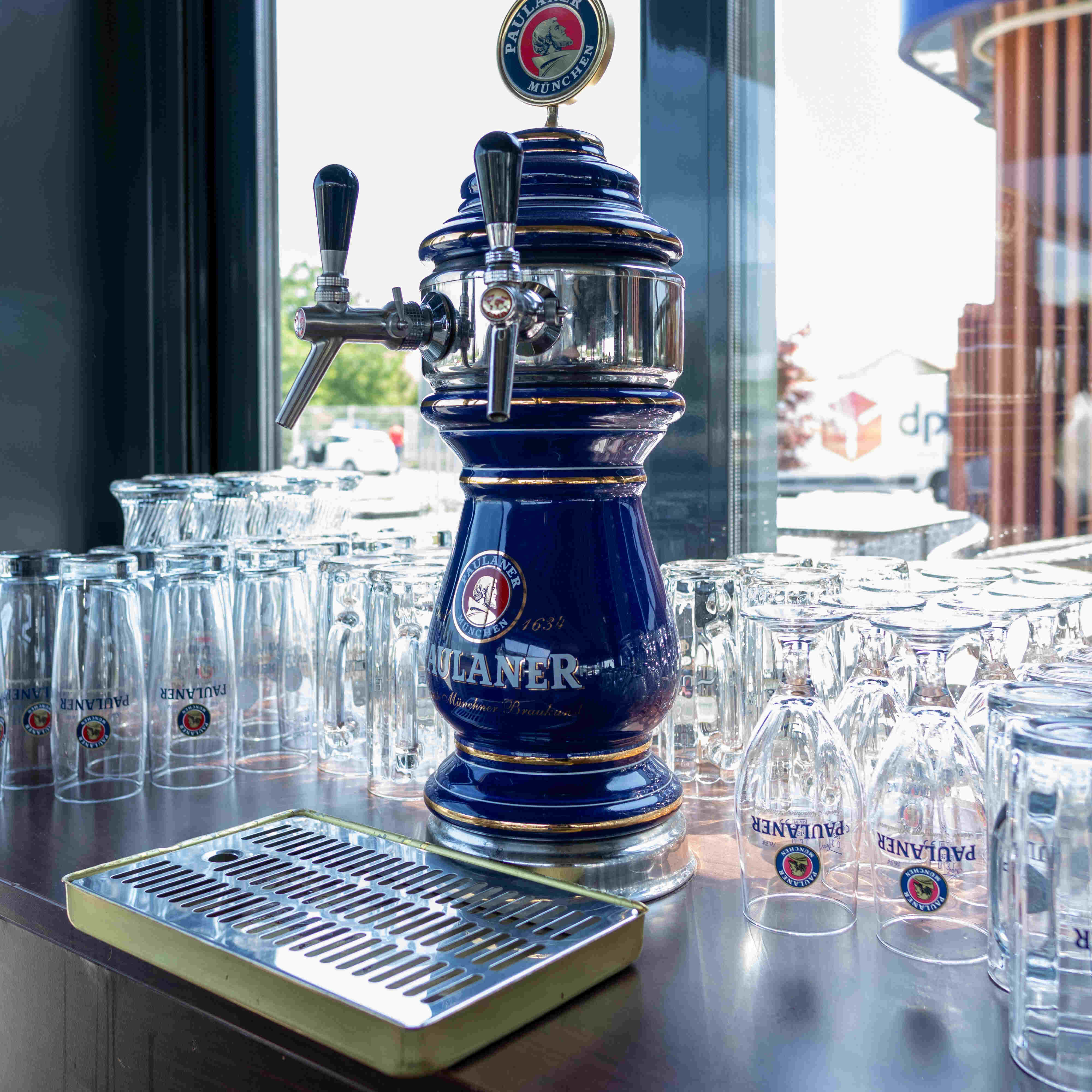 Paulaner pivski točionik okružen staklenim čašama u restoranu