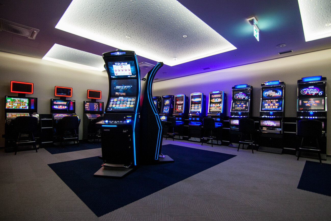Moderna prostorija s plavo osvijetljenim slot aparatima i bijelim stropom