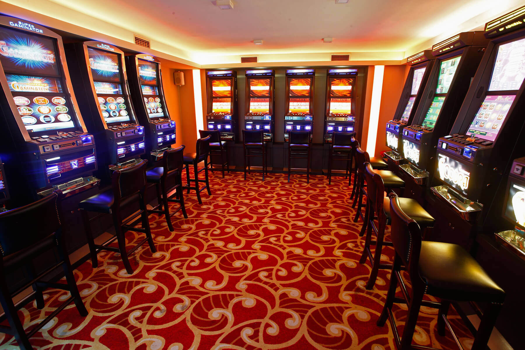 Red slot aparata s crvenim tepihom i crnim stolicama u kazinu