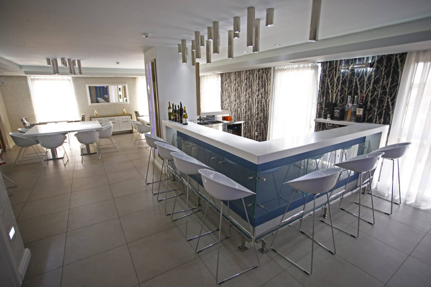 Šank lounge bara s visokim stolicama i bocama vina