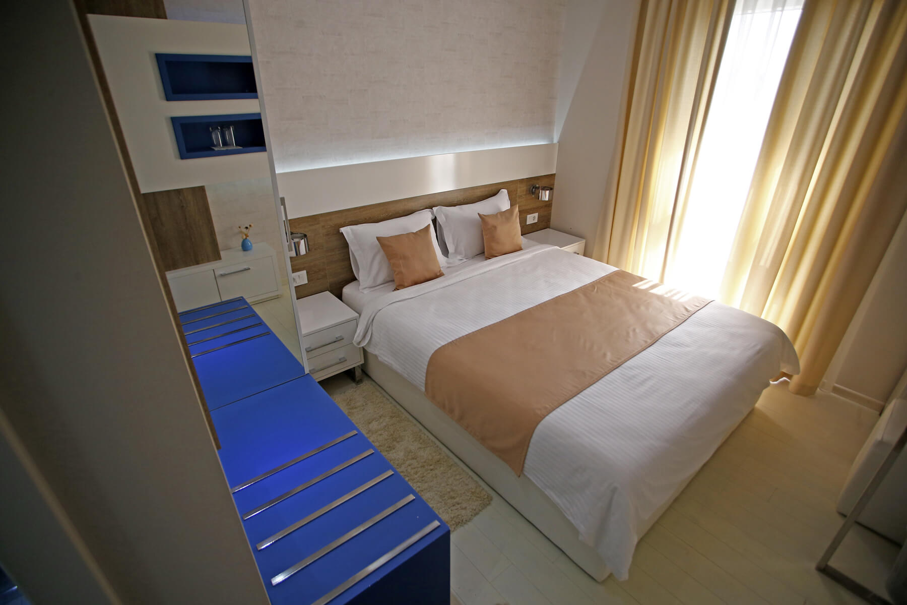 Moderna hotelska soba s bračnim krevetom u bež i plavim tonovima